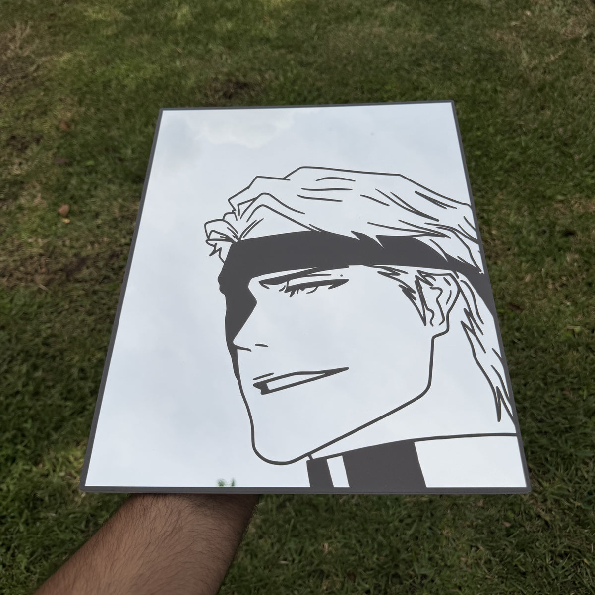 The Silent Blade Mirror, Bleach wall mirror, held in hand for scale