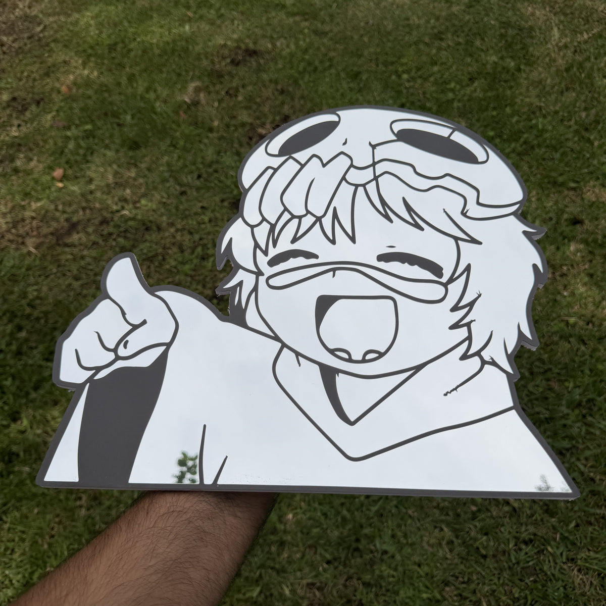 The Smiling Schemer Mirror, Bleach wall mirror, held in hand for scale